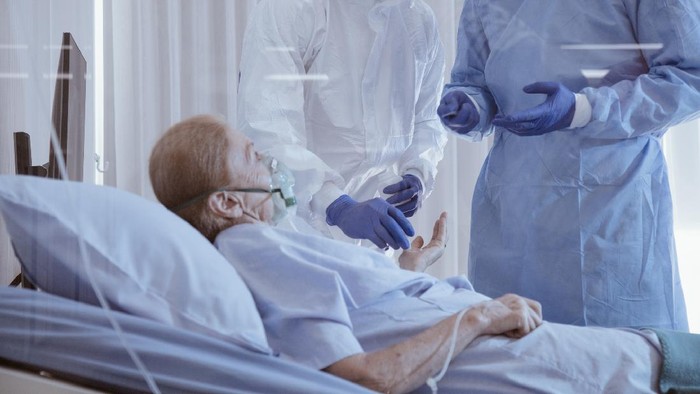 Infected patient on takecare of Doctor and nurse with x-ray Lung in quarantine lying on bed in hospital from coronavirus covid 19 disease. Covid19 or corona virus is world global social issue concept.