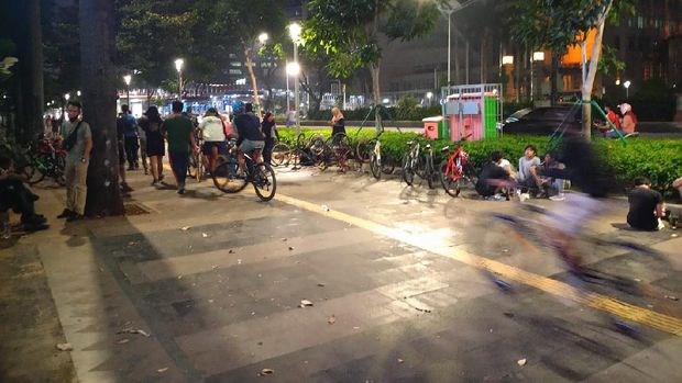 Masih ada warga Jakarta nongkrong di trotoar Jalan Sudirman.