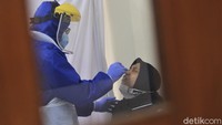 Tak hanya warga, para petugas juga turut mengenakan pakaian pelindung saat bertugas melakukan tes swab kepada warga.