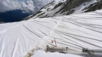 Lembaran-lembaran terpal yang masing-masing berukuran 70x5 meter itu berwarna putih, hampir tak bisa dibedakan dengan salju di bawahnya. (Miguel Medina/AFP)