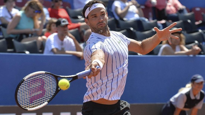 In this photo taken Saturday, June 20, 2020, Grigor Dimitrov from Bulgaria returns the ball to Croatias Borna Coric during their semifinal match at a tournament in Zadar, Croatia. Dimitrov says he has tested positive for COVID-19 and his announcement led to the cancellation of an exhibition event in Croatia where Novak Djokovic was scheduled to play on Sunday. (AP Photo/Zvonko Kucelin)