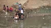 Kegiatan bermain bersama teman di bantaran kali itu menjadi hiburan bagi anak-anak tersebut.