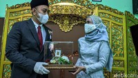 Pengantin pria menyerahkan mahar kepada pengantin wanita.
