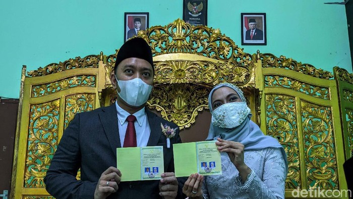 Melihat Prosesi Akad Nikah di Tengah Pandemi Pasangan pengantin Romdoni dan Dini Larasati menikah di KUA Cimanggis, Depok, Minggu (21/6). Prosesi akad nikah masih menggunakan protokol kesehatan COVID-19.