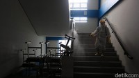 Petugas PMI menyusuri tangga untuk menyemprotkan disinfektan ke dinding pagar.