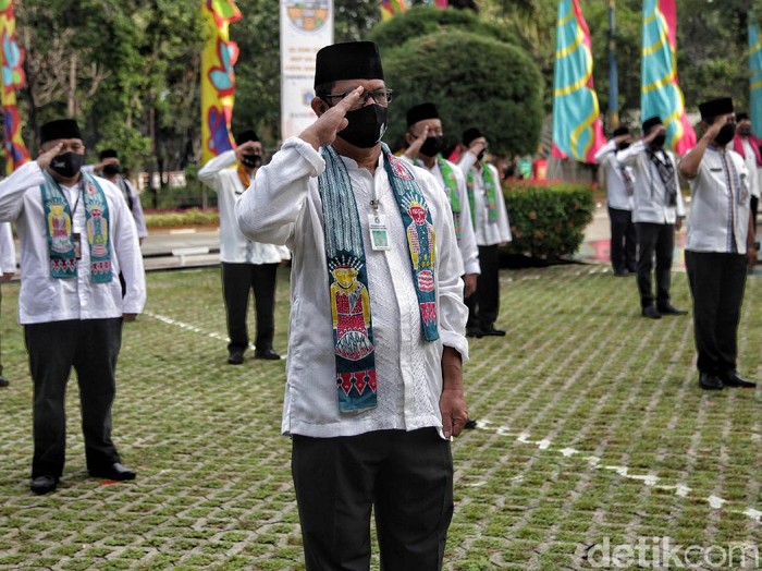 Sejumlah pegawai PNS melakuan  upacara HUT DKI Jakarta ke-493 dengan melakukan protokol kesehatan physical distancing di kawasan kantor Walikota Jakarta Utara, Senin (22/6). Upacara perdana di masa pandemi COVID-19 tersebut hanya melibatkan 50 peserta upacara dan mengutamakan ketentuan protokol kesehatan.