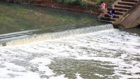 Tampak warga bermain di sekitar BKT yang airnya berbusa.