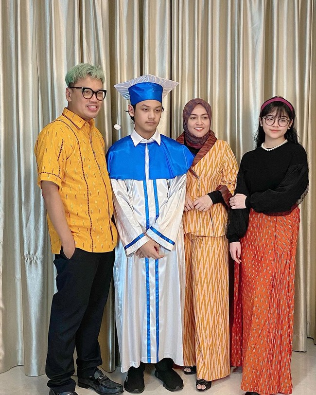 Nino Kuya, putra dari Uya dan Astrid Kuya juga lulus SMP tahun ini. Untuk sesi foto di rumah, Astrid memilih blazer kuning bermotif tenun dari IKAT Indonesia by Didiet Maulana. Uya Kuya juga tak mau kalah tampil bold dengan kemeja kuning cerahnya. (Foto: Instagram/@astridkuya)