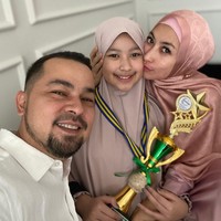 Kebahagiaan turut dirasakan Annisa Trihapsari dan Sultan Djorghi karena putri mereka,  Aquena Aziz Djorghi, lulus SD baru-baru. Untuk merayakannya, Anissa memilih busana musilm berwarna dusty pink dengan hijab sutra bermotif. (Foto: Instagram/@djorghisultan)