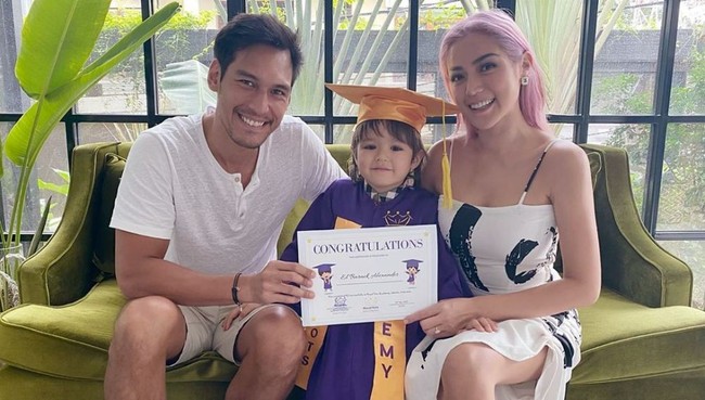 Putra Jessica Iskandar, El Barack, juga diwisuda secara virtual baru-baru ini. Untuk sesi foto bersama, Jessica dan calon suaminya, Richo Kyle tampil kompak dengan busana serba putih. Di saat Richo memilih tampilan kasual, Jessica bergaya maksimal dengan dress putih ketat bemotif abstrak. (Foto: Instagram/@inijedar)