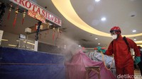 Personel damkar menyemprotkan cairan disinfektan di setiap lantai yang ada di pusat perbelanjaan ini.