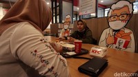Sejumlah warga makan di gerai KFC Galael, Jakarta, yang ditemani maskot Colonel Sanders, Selasa (23/6/2020).