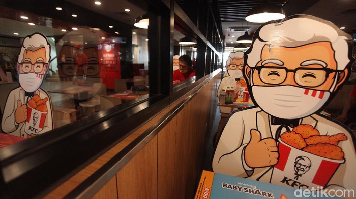 Makan Ayam Ditemani Colonel Sanders Protokol new normal kreatif hadir di gerai fast food KFC Indonesia. KFC menghadirkan maskot Colonel Sanders di kursi untuk menemani pengunjung.