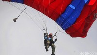 Penerjun payung Kopaska melayang-layang di langit Dermaga Pondok Dayung untuk membantu penyerbuan.