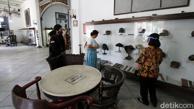 Petugas museum menyambut kedatangan tamu di depan pagar Museum Radya Pustaka di Solo, Jawa Tengah, Selasa (23/6). Museum tertua di Indonesia yang didirikan oleh Kanjeng Raden Adipati Sosrodiningrat IV pada 18 Oktober 1890 ini dibuka pertama kalinya sejak Kondisi Luar Biasa (KLB) diberlakukan  di Solo Maret lalu