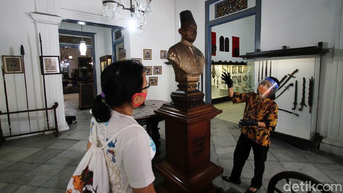 Petugas museum menyambut kedatangan tamu di depan pagar Museum Radya Pustaka di Solo, Jawa Tengah, Selasa (23/6). Museum tertua di Indonesia yang didirikan oleh Kanjeng Raden Adipati Sosrodiningrat IV pada 18 Oktober 1890 ini dibuka pertama kalinya sejak Kondisi Luar Biasa (KLB) diberlakukan  di Solo Maret lalu
