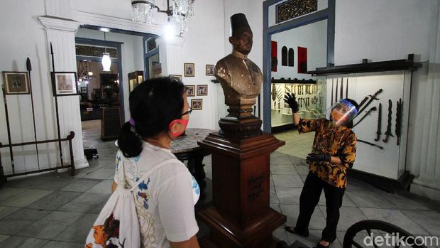 Petugas museum menyambut kedatangan tamu di depan pagar Museum Radya Pustaka di Solo, Jawa Tengah, Selasa (23/6). Museum tertua di Indonesia yang didirikan oleh Kanjeng Raden Adipati Sosrodiningrat IV pada 18 Oktober 1890 ini dibuka pertama kalinya sejak Kondisi Luar Biasa (KLB) diberlakukan  di Solo Maret lalu