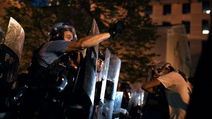 Polisi mencoba menghalangi para demonstran yang ingin merobohkan patung presiden ketujuh AS (AFP Photo)