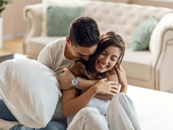 1132153686 Happy affectionate couple enjoying in their love while embracing in bedroom in the morning.