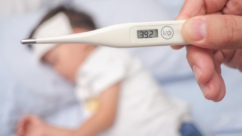 Fever, Close-up medical thermometer, Parent / Father measuring temperature of his ill kid, Asian 3 - 4 years old toddler boy gets high fever lying on bed with cold compress on forehead to cool a fever