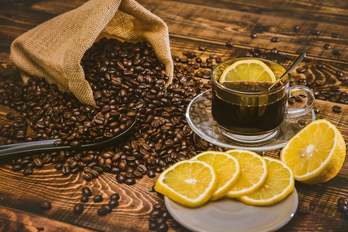 Coffee cup and beans on old kitchen table. Top view with copy space for your text. coffee bag and with sliced 