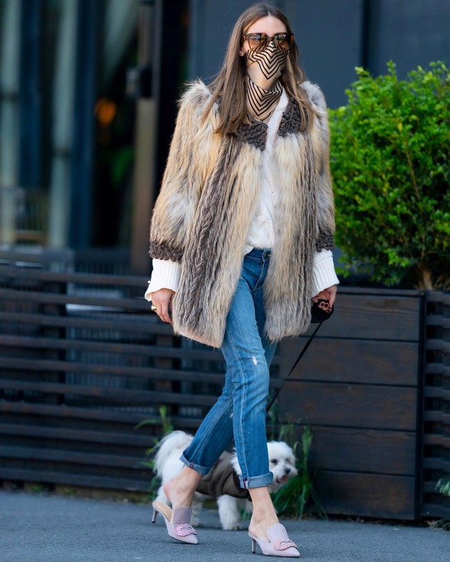 Saat harus keluar rumah di tengah pandemi COVID-19, Olivia Palermo memastikan gayanya tetap effortless chic sebagaimana biasanya.  Sebuah scarf bermotif garis ia pakai sebagai pengganti masker. Padu-padan jeans, blus dan outerwear bulu dengan selop feminin sukses memaksimalkan gaya Oliva. (Foto: Instagram/@oliviapalermo)