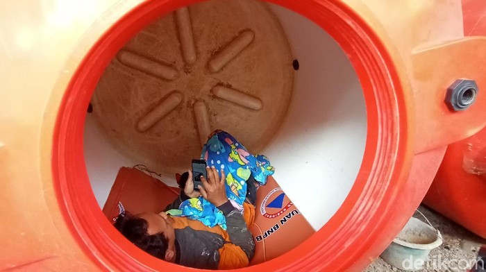 Salah satu relawan pemulasaraan jenazah, Kristanto (39) saat tiduran di tangki air di kantor BPBD Kudus, Rabu (24/6/2020).