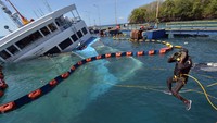 Penyelam tampak melompat ke laut untuk melakukan proses evakuasi kendaraan dari kapal yang tenggelam tersebut.