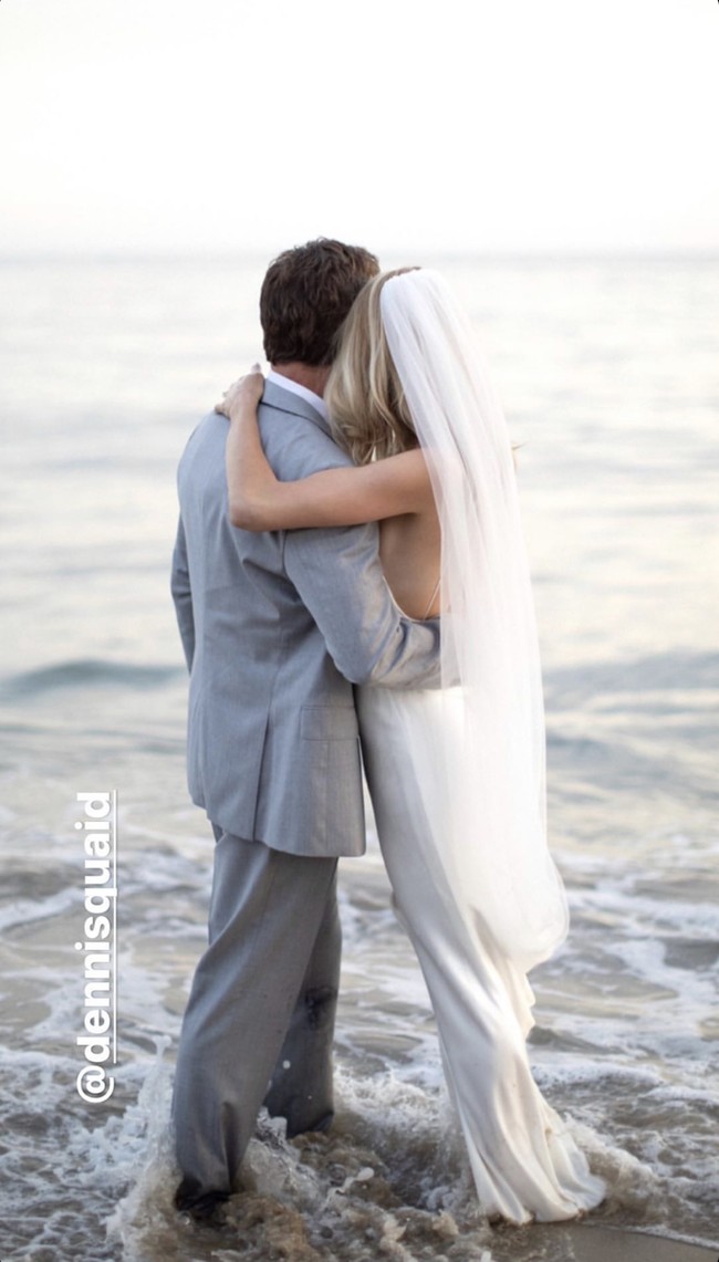 Dennis menggunakan setelan jas berwarna abu-abu dari Hugo Boss, sedangkan mempelai wanitanya tampil cantik mengenakan gaun pengantin backless berwarna putih dan membawa buket mawar serta lili yang didesain oleh S.R. Hogue & Co. florist. Foto: Instagram story @elizabethmessina