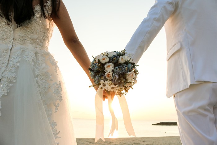 ilustrasi pernikahan Two couple have bouquet at the sunset beach