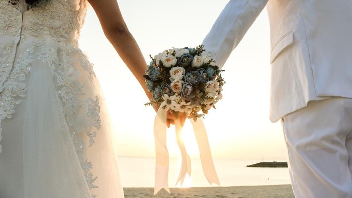 ilustrasi pernikahan Two couple have bouquet at the sunset beach