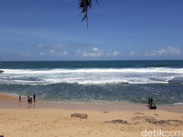 Tampak beberapa wisatawan tengah bersantai di pinggir pantai dengan menggunakan masker dan beberapa wisatawan lainnya tampak asyik bermain air. Tampak beberapa wisatawan tengah bersantai di pinggir pantai dengan menggunakan masker dan beberapa wisatawan lainnya tampak asyik bermain air.