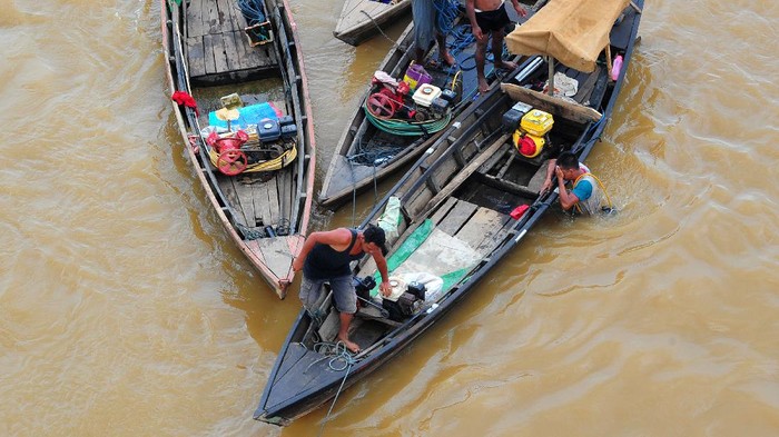 PENYELAM PENCARI EMAS DI SUNGAI BATANGHARI Penyelam bersiap turun ke dasar sungai menggunakan selang pernapasan yang terhubung dengan mesin kompresor di Sungai Batanghari, Jambi, Rabu (24/6/2020). Para penyelam meyakini di bagian dasar Sungai Batanghari yang pernah menjadi jalur perdagangan dunia dan tempat ditemukannya pecahan keramik asal Asia Tenggara, tembikar asal Persia, dan perhiasan emas peninggalan masa kerajaan Melayu kuno tersebut masih bisa ditemukan benda-benda berharga. ANTARA FOTO/Wahdi Septiawan/foc.