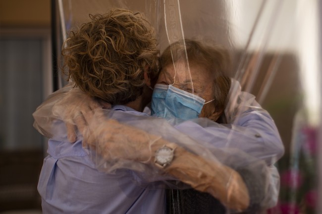 Giliran Beatriz Segura yang memeluk ibunya, Isabel López. Berusia 96 tahun, Isabel berada di kelompok usia yang paling rentan terinfeksi virus Corona. (Foto: AP/Emilio Morenatti)