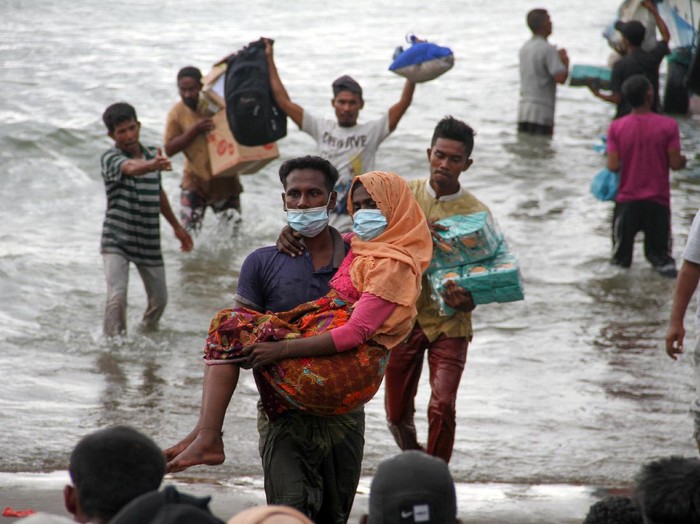 Warga melakukan evakuasi paksa pengungsi etnis Rohingya dari kapal di pesisir pantai Lancok, Kecamatan Syantalira Bayu, Aceh Utara, Aceh, Kamis (25/6/2020). Warga terpaksa melakukan evakuasi paksa 94 orang pengungsi etnis Rohingya ke darat yang terdiri dari 15 orang laki-laki, 49 orang perempuan dan 30 orang anak-anak tanpa seizin pihak terkait, karena warga menyatakan tidak tahan melihat kondisi pengungsi Rohingya yang memprihatikan di dalam kapal sekitar 1 mil dari bibir pantai dalam kondisi. terutama anak-anak dan wanita dalam kondisi lemas akibat dehidrasi dan kelaparan. ANTARA FOTO/Rahmad/aww.