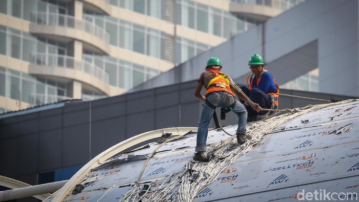 Sejumlah pekerja di proyek LRT di kawasan Kuningan, Jakarta, bekerja keras menyelesaikan tugas. Bak Spiderman, mereka bergelantungan mempertaruhkan nyawa.