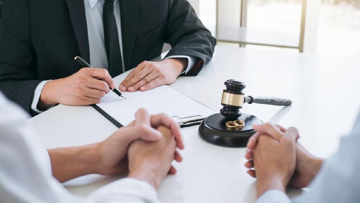 Agreement prepared by lawyer signing decree of divorce (dissolution or cancellation) of marriage, husband and wife during divorce process with male lawyer or counselor and signing of divorce contract.