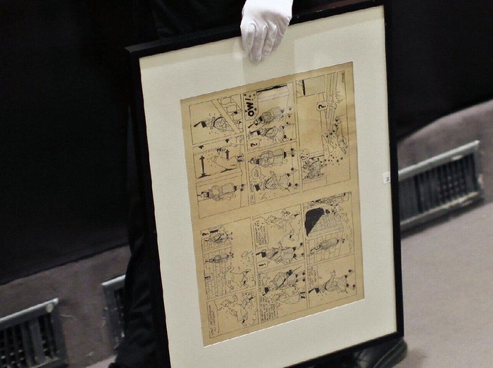 FILE - In this May 29, 2010 file photo, a porter holds an inked and water-painted original panel from the 1938 King Ottokars Sceptre album drawn by Belgian creator Herge during the auction of rare memorabilia of Tintin, at the Drouot auctions house, in Paris. Four Paris auctioneers and dozens of auction workers are going on trial Monday March 14, 2016, accused of a vast and long-lasting scheme to steal thousands of pieces of artwork and other valuable items. (AP Photo/Thibault Camus, File)