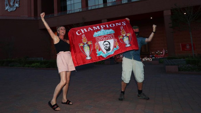 Liverpool LIVERPOOL, ENGLAND - JUNE 25: Liverpool fans celebrate as their team clinches the Premier League title at Anfield on June 25, 2020 in Liverpool, England. Liverpool are crowned Premier League champions as nearest rivals Manchester City fail to beat Chelsea. Liverpool claim their first championship in 30 years. (Photo by Jan Kruger/Getty Images)