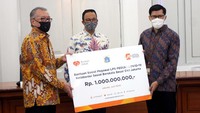 Gubernur DKI Jakarta Anies Baswedan (tengah) secara simbolis menerima bantuan dari Ketua Dewan Komisioner Lembaga Penjamin Simpanan (LPS) Halim Alamsyah (kiri) dan perwakilan Ikatan Pegawai LPS di Balai Kota DKI Jakarta.