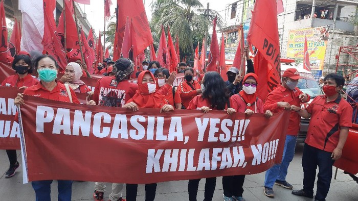 Massa DPC PDIP Jakut bentangkan spanduk di Jalan Yos Sudarso, Jakarta Utara, Jumat (26/6/2020).