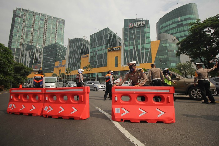 Petugas gabungan melakukan penyekatan saat Pembatasan Sosial Berskala Besar (PSBB) Tahap III di Bundaran Waru, Surabaya, Jawa Timur.