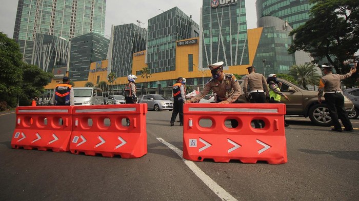 Petugas gabungan melakukan penyekatan saat Pembatasan Sosial Berskala Besar (PSBB) Tahap III di Bundaran Waru, Surabaya, Jawa Timur.