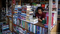 Seorang pedagang tampak beraktivitas di kiosnya sembari menunggu pengunjung datang untuk membeli buku di kawasan tersebut.
