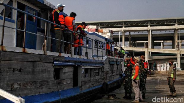 Petugas memeriksa suhu penumpang di kapal KMP Arwana dengan tujuan Pulau Pramuka di kawasan Pelabuhan Kali Adem, Muara Angke, Jakarta Utara,  Jumat (26/6). Saat ini pelabuhan Kali Adem Muara Angke yang melayani perjalananan ke pulau seribu dan arah sebaliknya telah dibuka kembali.