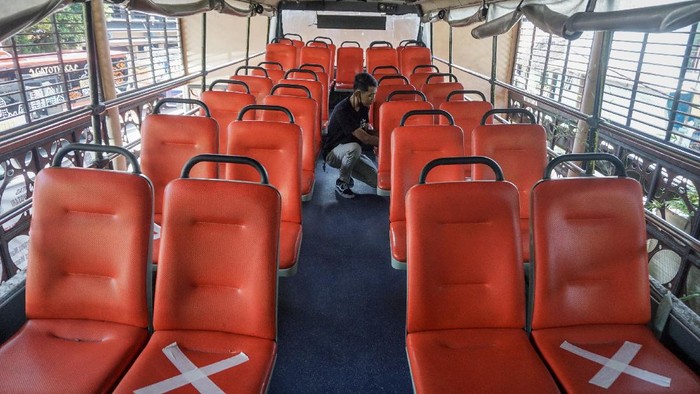 PERSIAPAN NORMAL BARU BUS TINGKAT WISATA Petugas Dinas Perhubungan menempelkan tanda jaga jarak (physical distancing) di kursi bus tingkat wisata di kantor Dinas Perhubungan, Solo, Jawa Tengah, Jumat (26/6/2020). Bus tingkat wisata keliling Kota Solo akan mulai dioperasikan kembali pada 27 Juni 2020 sesuai tatanan normal baru dengan menerapkan protokol kesehatan seperti wajib mengenakan masker, menjaga jarak dan mencuci tangan. ANTARA FOTO/Mohammad Ayudha/wsj.