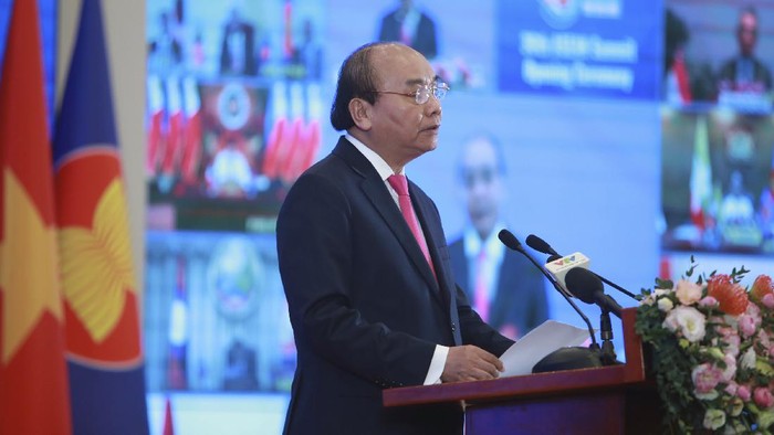 Vietnamese Prime Minister Nguyen Xuan Phuc delivers a speech in front of a TV screen showing ASEAN leaders at the opening ceremony of the 36th ASEAN Summit in Hanoi, Vietnam Friday, June 26, 2020. Leaders from the Southeast Asian ten-nation bloc hold the bi-annual summit via online video conference to discuss regional issues. (AP Photo/Hau Dinh)
