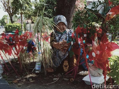 Siti Rokhimah berjualan kincir angin di jalan Pramuka, Klaten, Jumat (26/6/2020).