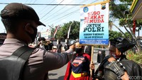 Dua pegiat antinarkotika mengenakan kostum superhero Batman dan Supergirl saat hendak membagikan nasi kepada para tahanan narkotika serta anggota kepolisian di Polresta Sukoharjo, Jawa Tengah, Jumat (26/6/2020).