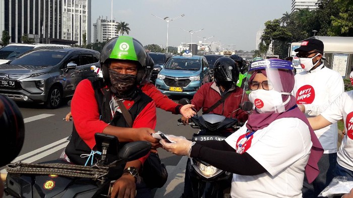 Wakil Ketua KPK Lili Pintauli Siregar membagi-bagikan masker ke pengendara yang melintas di Jalan Jenderal Sudirman, Jakarta Pusat, Jumat (26/6/2020).